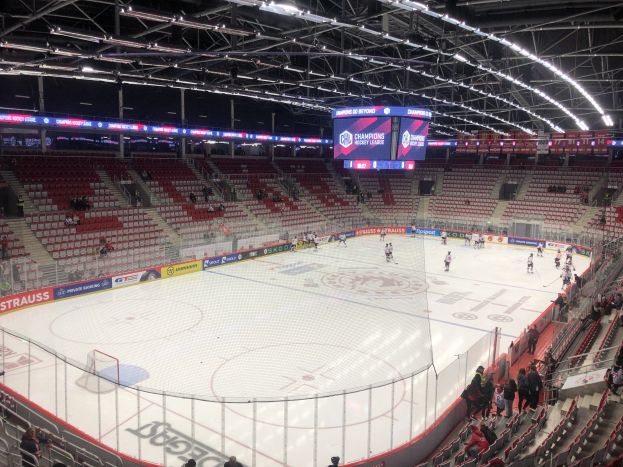 Eishockeyspiel in einer großen Arena zwischen den St. Louis Blues und den Detroit Red Wings, mit Zuschauern auf den Sitzen und Stehplätzen in der Nähe der Eisfläche.