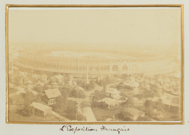 Altes Schwarz-Weiß-Foto eines Stadions in einer städtischen Umgebung, umgeben von Gebäuden, Bäumen und Strommasten, mit sichtbarem Text unten.