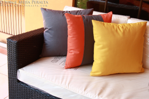 Ein Sofa mit Kissen vor einem Glasfenster und einer Wand, mit Text oben auf dem Bild.