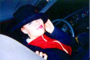 Eine Frau neben einem Kraftfahrzeug.