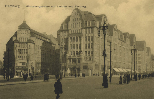 Altes Schwarz-Weiß-Foto von Menschen, die eine Straße in Hamburg, Deutschland, entlanggehen, gesäumt von Gebäuden, Straßenlaternen, Lampen und Kraftfahrzeugen unter einem bewölkten Himmel.