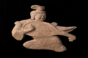 Eine Steinskulptur eines Mannes in einem langen Gewand, der ein Musikinstrument spielt und einen friedlichen Ausdruck hat, vor einem schwarzen Hintergrund.