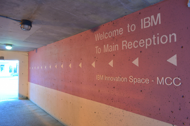 Wand mit beleuchteter Schrift, die "Willkommen bei IBM" lautet, und eine Tür im Hintergrund, die "IBM Innovation Space MCC" trägt.