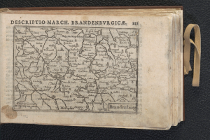 Ein aufgeschlagenes Buch, das eine detaillierte Karte von Brandenburgs geografischen Merkmalen zeigt, liegt auf einer schwarzen Oberfläche.