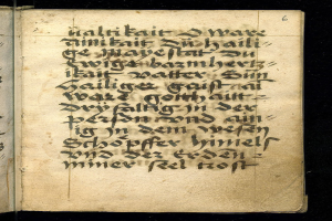 Ein offenes mittelalterliches Manuskript, eine Bibl Mazarine, mit detaillierter schwarzer Kalligraphie auf seinen Seiten gegen einen dunklen Hintergrund.