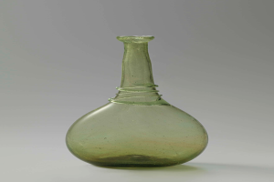 Ein grüner Glasweinkelch mit Verschluss, zylindrischer Form, breiter Basis, engem Hals und detaillierten Verzierungen, mit einem glänzenden Finish.