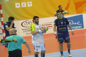 Eine Gruppe von Männern steht auf einem Futsal-Platz, einer hält den Ball, links ist ein Tor und im Hintergrund Schilder zu sehen.