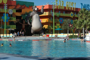 Ein Schwimmbad mit blauem Wasser und Menschen beim Schwimmen, mit Cartoon-Bildern und Stangen im Hintergrund.