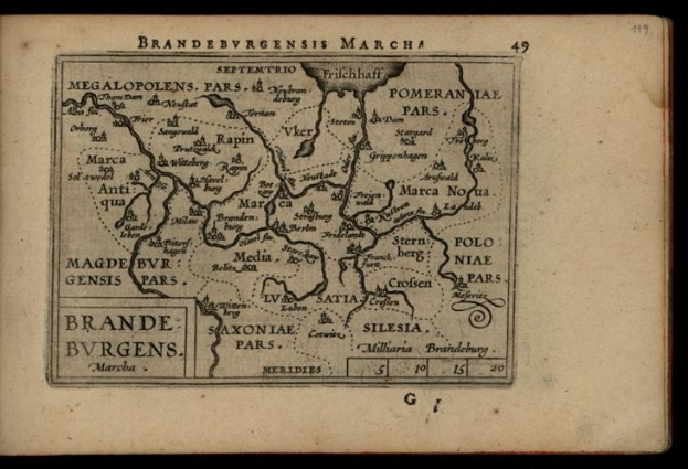 Altes Buch mit einer detaillierten Karte der Brandenburg-Region Deutschlands auf einem schwarzen Hintergrund, begleitet von Texten über die Region.
