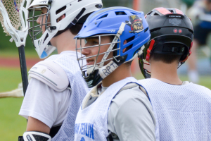 Drei Spieler in weißer Jacken und Helmen mit unscharfem Hintergrund.