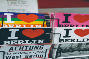 Ein Gestell mit verschiedenen Büchern und Postern mit der Aufschrift 'I Love Berlin' vor einem sanft unscharfen Hintergrund.