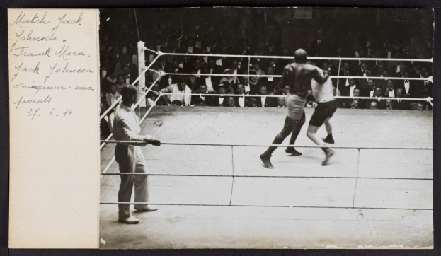 Schwarz-weiß-Foto von zwei Boxern in einem Ring mit einem Schiedsrichter und Zuschauern, beschriftet "Jack Johnson vs Frank Morgan" in der oberen linken Ecke.