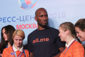 Eine Gruppe von medaillentragenden Individuen steht auf einer Bühne mit einem Banner, das einen Fußball und Text zeigt und die 2018 FIFA WM Russland feiert.