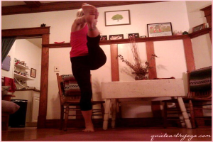 Eine Frau trainiert in einem Raum mit einem Tisch, Stühlen, einer Blumenvase und mehreren Fotorahmen an der Wand; ein weiterer Raum mit einem Tisch, Regalen und einem Fotorahmen ist durch eine offene Tür links zu sehen, mit Text in der rechten unteren Ecke.